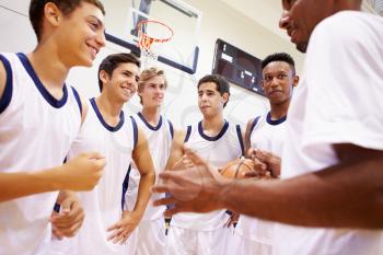 Male High School Basketball Team Having Team Talk With Coach