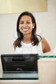 Portrait Of Female Receptionist At Hotel Front Desk