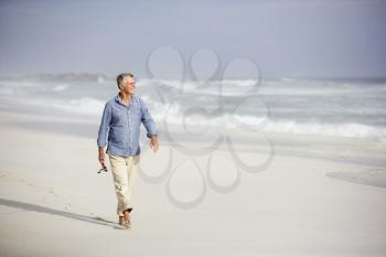 Senior man walking on beach