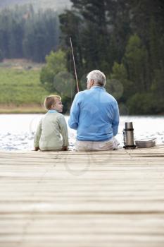 Senior man fishing with grandson