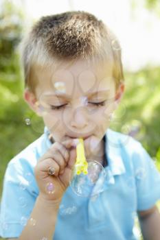 Young boy blowing bubbles outdoors