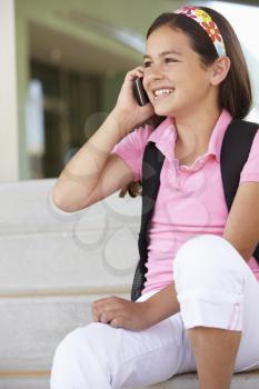Pre teen girl with phone at school