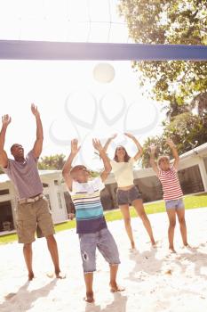 Family Playing Game Of Volleyball In Garden