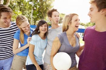 Group Of Young Friends Playing Volleyball Match