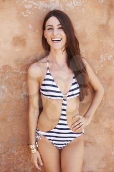 Pretty Young Woman Wearing Swimsuit Leaning Against Wall