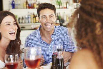 Group Of Young Friends Enjoying Meal In Outdoor Restaurant