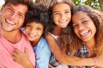 Parents Giving Children Piggyback Ride Outdoors