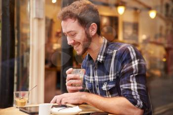 Man Viewed Through Window Of Caf Using Digital Tablet