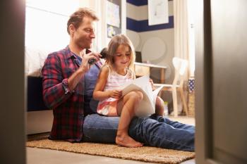 Father brushing young daughter's hair