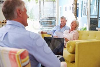 Senior Couple At Home Meeting With Financial Advisor