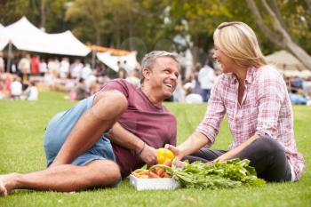 Couple With Fresh Produce Bought At Outdoor Farmers Market