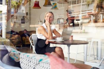 Business woman sitting in small coffee shop