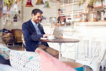 Young man using laptop at a cafe