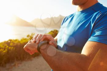 Young man checking time on his sports watch