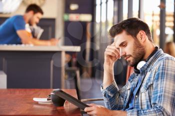 Man using digital tablet in a coffee shop