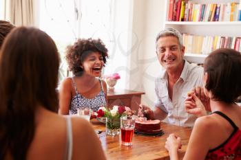 Friends sitting at a dining table laughing together