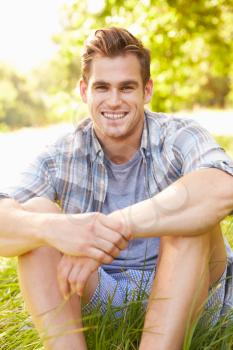 Young man sitting on grass relaxing