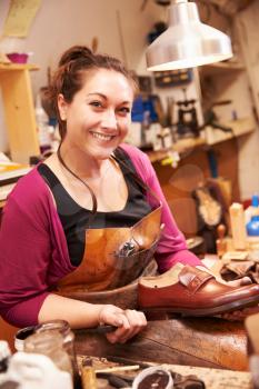 Woman shoemaker making shoes in a workshop