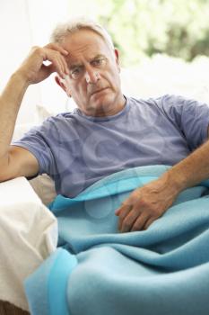 Senior Man Feeling Unwell Resting Under Blanket
