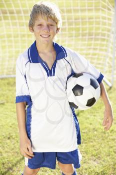 Young Boy Dressed In Soccer Kit Standing By Goal