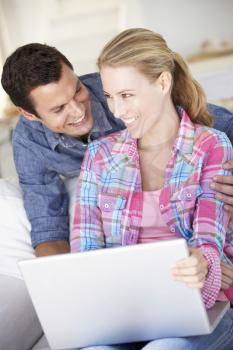 Young Couple Using Laptop Computer At Home