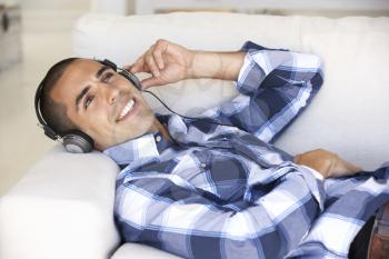 Young Man Relaxing Listening To Music At Home