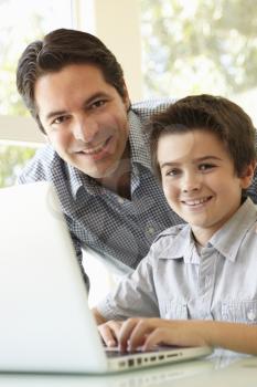 Hispanic Father And Son Using Laptop