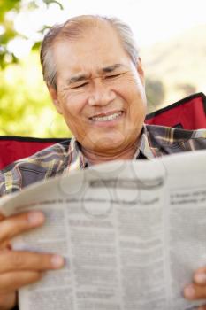 Senior Asian man reading outdoors