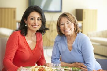 Hispanic Mother With Adult Daughter Enjoying Meal At Home