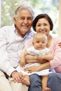 Hispanic grandparents at home with grandchild