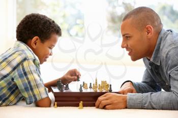 Father playing chess with son