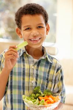 Young boy eating raw vegetables