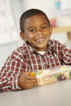 Elementary Age Schoolboy Eating Healthy Packed Lunch In Class 