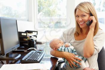 Mother working in home office with baby