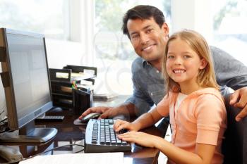 Father and daughter using computer in home office