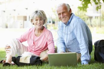 Senior couple using laptop outdoors