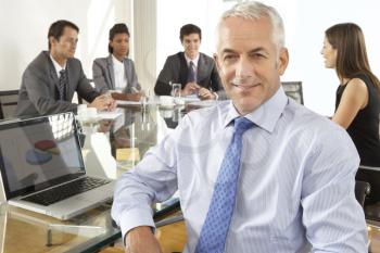 Businessman Sitting Around Boardroom Table With Colleagues