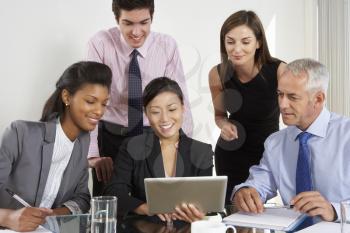 Group Of Business People Having Meeting Around Tablet Computer At Glass Table