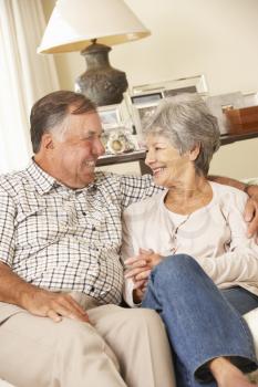 Retired Senior Couple Sitting On Sofa At Home Together
