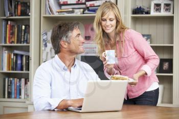 Couple Having Working Lunch In Home Office Together