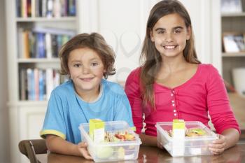 Two Children With Healthy Lunchboxes In Kitchen