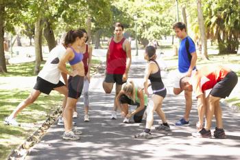 Group Of Runners Warming Up In Park