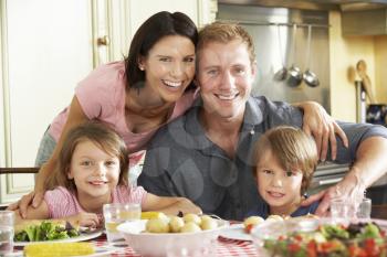 Family Eating Meal Together In Kitchen