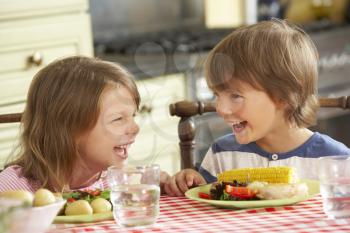 Boy And Girl Eating Meal In Kitchen