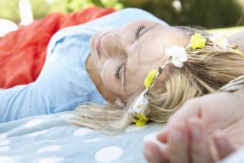 Woman Lying In Park Wearing Flowers Around Hair