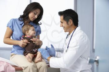 Doctor In Surgery Examining Baby Girl