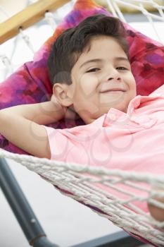 Young Boy Relaxing In Garden Hammock Together