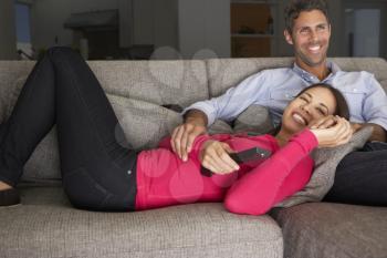 Hispanic Couple On Sofa Watching TV