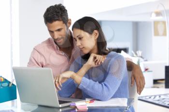 Couple Working At Laptop In Home Office