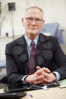 Portrait Of Male Consultant Working At Desk